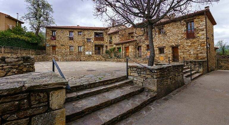Plaza del pueblo de La Horcajuela de la Sierra con casas de piedra
