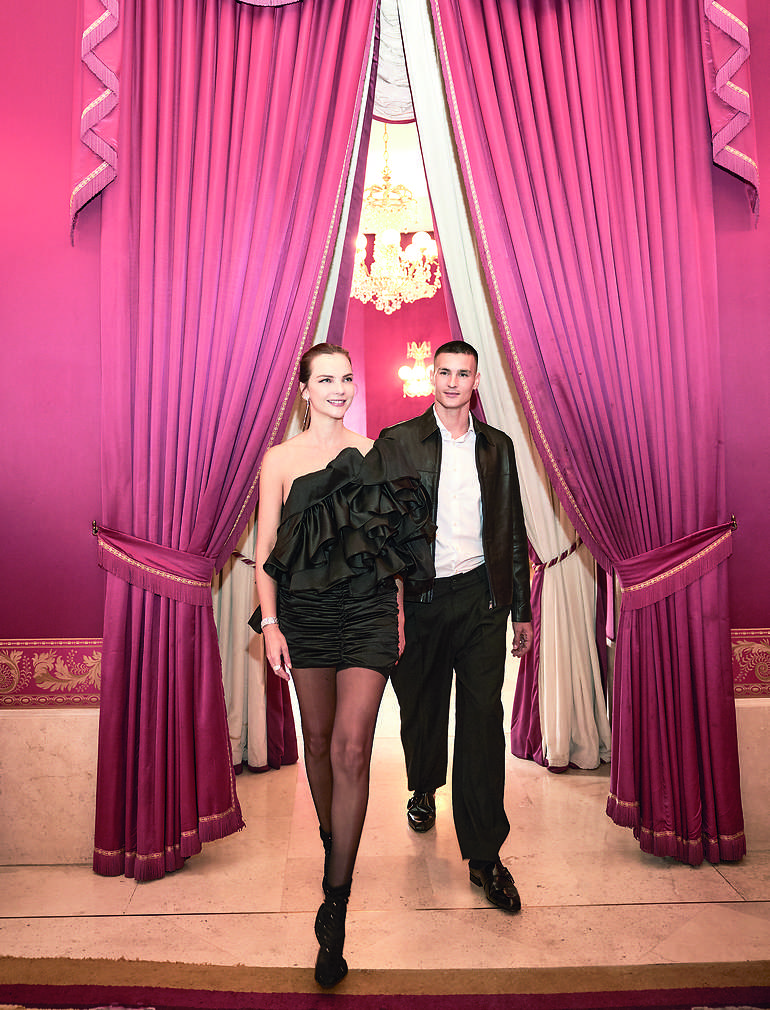 Ella: Pendientes y pulsera, de Carrera y Carrera. Anillo, de Swarovski. Vestido, de Paloma Suárez. Medias, de Dim. Zapatos, de Jimmy Choo.  Él: Camisa, de Mango. Chaqueta de cuero, de Zara. Pantalón, de Adolfo Domínguez. Zuecos, de Jimmy Choo.